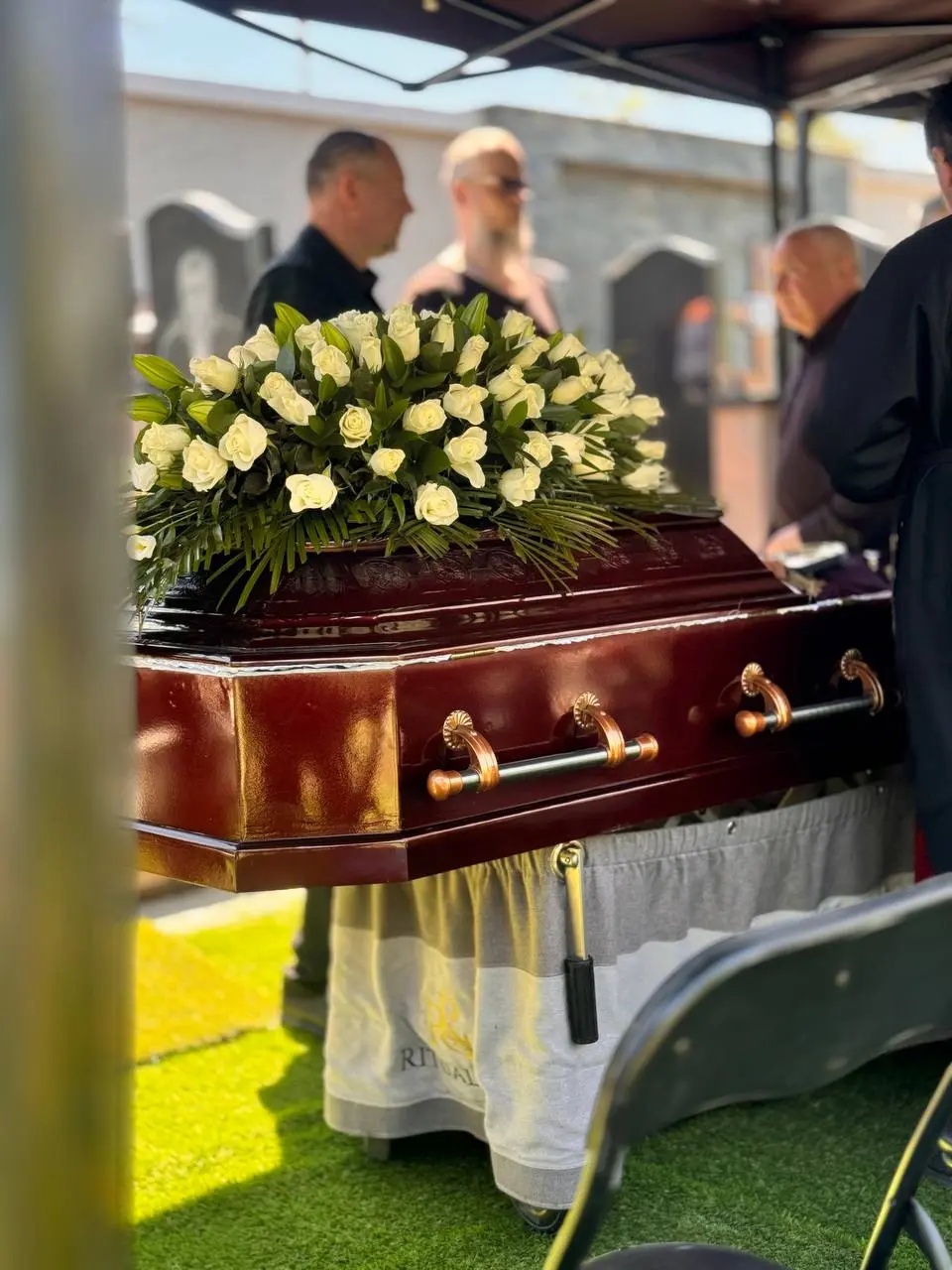 White rose arrangement on a casket during the ceremony